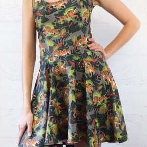 May include: A gray sleeveless dress with a print of orange and black tigers in a jungle setting.