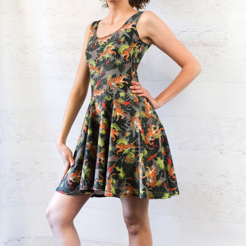May include: A green, sleeveless dress with a tiger print. The dress has a fitted bodice and a flared skirt.