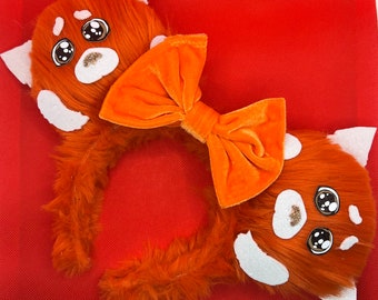 May include: A red panda headband with orange faux fur, white accents, and a large orange bow. The headband features cartoon eyes and a glittery nose, perfect for cosplay or themed events.