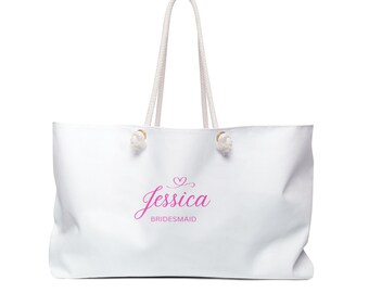 May include: White tote bag with rope handles. The bag features the name "Jessica" in pink script with a heart above it, and the word "Bridesmaid" below. The bag is designed for carrying items.