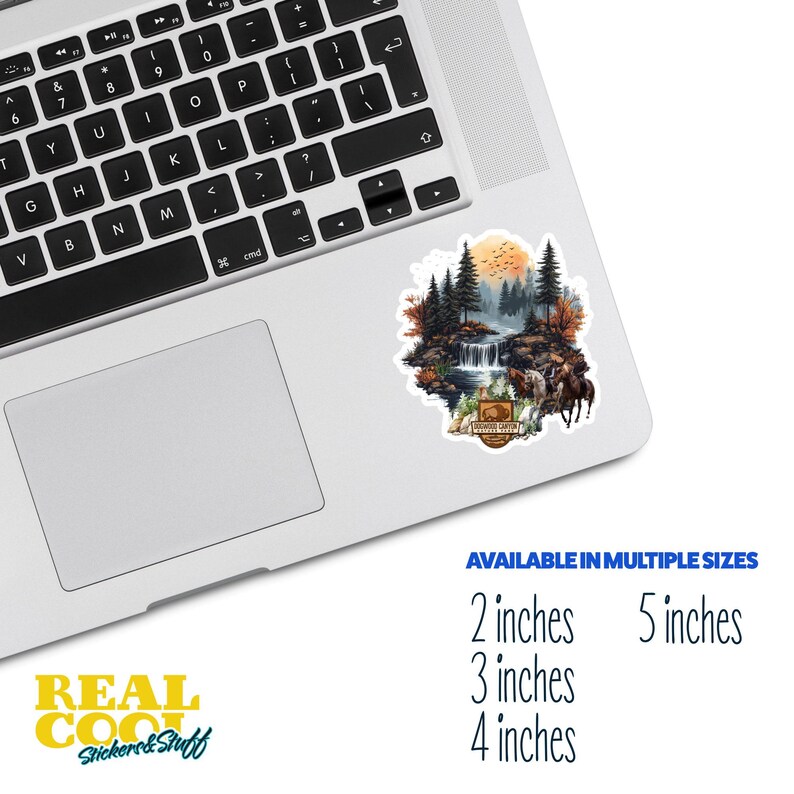 May include: A sticker featuring a watercolor illustration of a forest scene with a waterfall, trees, and a sunset. The sticker has the text "Woodrow Canyon Wilderness" in a brown rectangle with a white border.