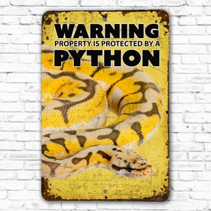 May include: A yellow metal sign with the text "WARNING PROPERTY IS PROTECTED BY A PYTHON" in black letters. A yellow and black python is pictured on the sign.