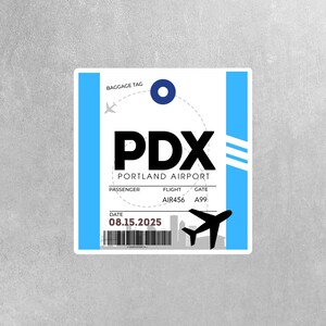 May include: A blue and white luggage tag with the text "PDX PORTLAND AIRPORT" and a small airplane icon. The tag also includes the date "08.15.2025", flight number "AIR456", and gate number "A99".