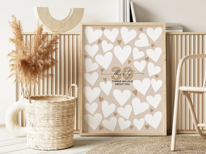 May include: A printable 30th birthday party game with a beige background and white hearts. The text "Thirty Things We Love About You" is written in gold glitter.