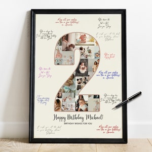 May include: A white photo collage in a black frame with a large number "2" made of photos. The number is decorated with a pink and gold outline. The text "Happy Birthday Michael!" is written below the number. The frame is on a wooden floor.
