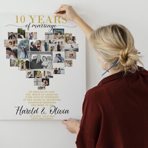 May include: A white canvas print with a heart-shaped collage of photos celebrating a 10th wedding anniversary. The text "10 YEARS of marriage" is in gold lettering at the top. The names "Harold & Olivia" are written in black cursive below the collage. The date "08.10.2014 - 08.18.2024" and the words "HAPPY ANNIVERSARY" are also included.