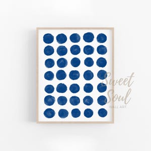 May include: A digital print of a blue and white abstract pattern with a repeating circle design. The print is framed in a light wood frame.