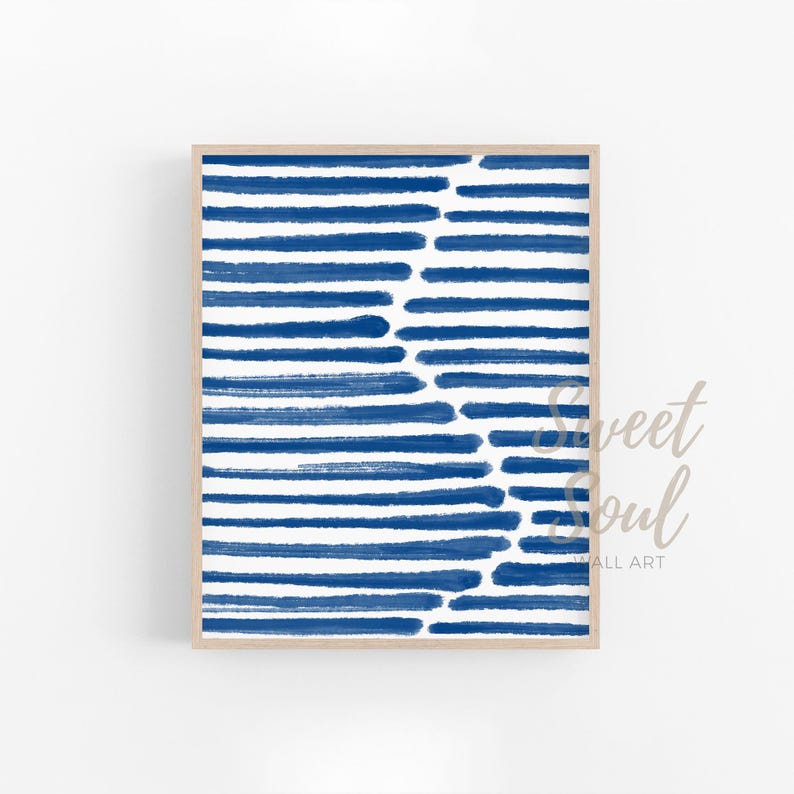 May include: Abstract art print featuring a blue and white striped pattern. The stripes are painted in a brushstroke style, creating a textured look. The print is framed in a light wood frame.