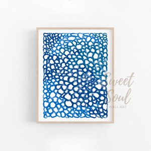 May include: Abstract watercolour painting in shades of blue, featuring a pattern of overlapping circles. The artwork is framed in a light wood frame.