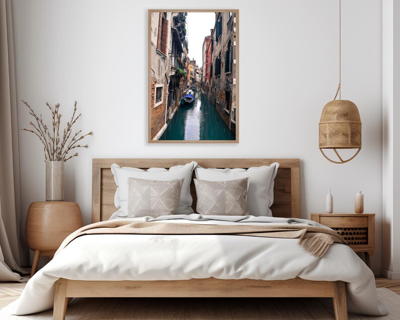 May include: A photograph of a narrow canal in Venice, Italy. The canal is lined with colorful buildings and a small boat is floating in the water.