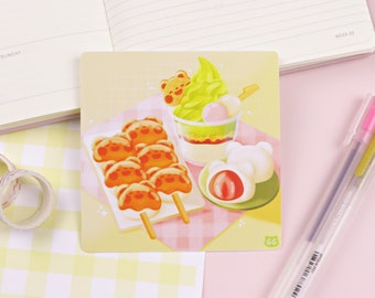 May include: A colorful illustration of Japanese street food. The image features a green tea ice cream sundae, a skewer of mochi with bear faces, and a strawberry mochi. The background is a pink and white checkered pattern.