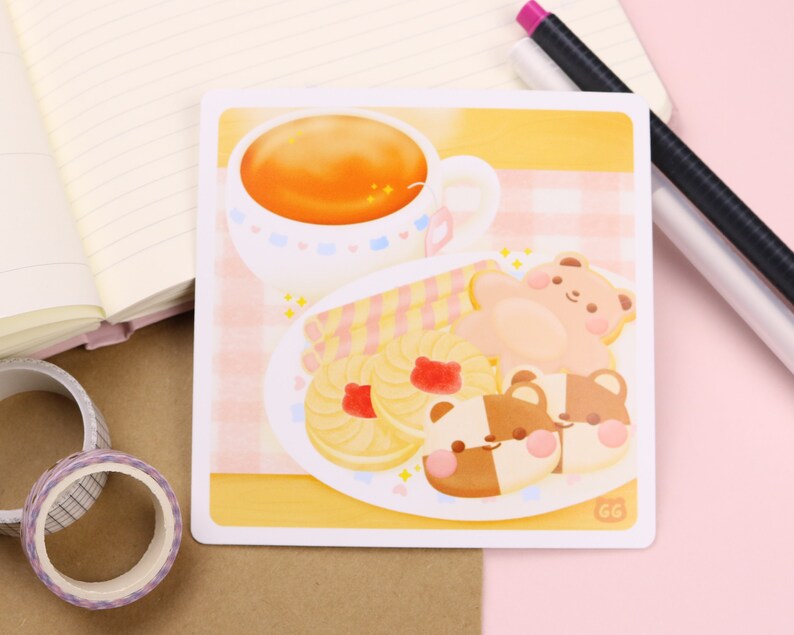 May include: A yellow and pink illustration of a cup of tea, a plate of cookies, and two bear-shaped cookies. The cookies are decorated with pink and brown frosting. The plate is on a pink and white checkered tablecloth.