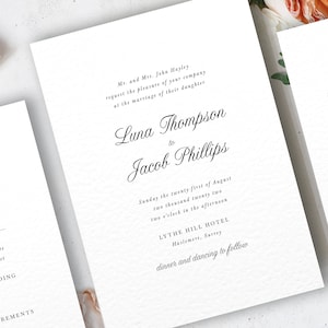 May include: A set of wedding stationery featuring three white cards with black calligraphy. The main invitation announces the marriage of Luna Thompson and Jacob Phillips. Includes RSVP and information cards.