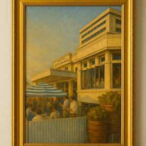 May include: A framed painting of the Hotel Esplanade, featuring a blue and white striped awning over an outdoor dining area. The artwork has a gold frame and depicts people dining outside. A glass and a dark bottle are on a wooden surface.