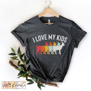 May include: A dark grey t-shirt with a white graphic that says "I love my kids" and features a line of five goats in rainbow colours.