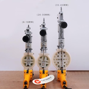 Può includere: Sono mostrate tre pistole per tufting con diverse profondità dell'ago (8-18mm, 20-30mm e 35-45mm). Ogni pistola ha un'impugnatura gialla, un corpo color crema e un telaio in metallo argentato. È visibile il marchio "Tuft Select".