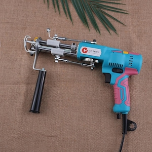 May include: A white ceramic mug with a black handle and the text "But First, Coffee" in a black, handwritten-style font. The mug is on a white surface.