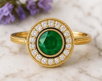 May include: A gold ring featuring a round, faceted green center stone surrounded by a thin black border and a halo of small, round, clear white stones. The gold band has a beaded texture along the edges, creating a detailed, circular design.