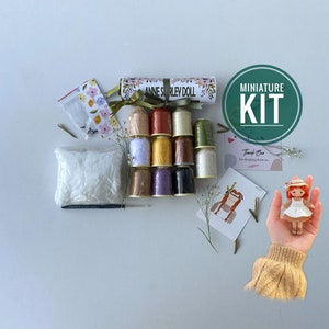Peut inclure: Un kit de fabrication de poupée miniature avec une variété de fils à broder de différentes couleurs, un petit sac de rembourrage, un crochet et un patron imprimé. Le kit comprend le texte "Anne Shirley Doll" et "Miniature Kit".