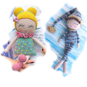 May include: Two crocheted dolls, one with yellow hair and a pink and green dress, the other with a blue and white striped outfit and a brown sleeping cap.