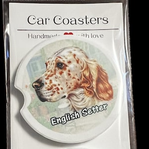 May include: Two white ceramic car coasters with a brown and white English Setter dog image on each. The coasters have a scalloped edge and the text "English Setter" is printed on each coaster.