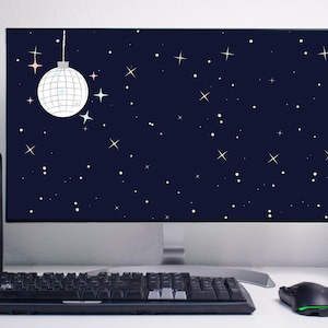 Könnte beinhalten: Ein Computermonitor mit einem dunkelblauen Hintergrund mit weißen Sternen und einer silbernen Discokugel, die von oben hängt. Der Monitor steht auf einem weißen Schreibtisch mit einer schwarzen Tastatur und einer schwarzen Maus.
