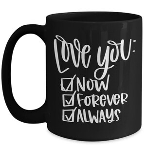 May include: Black ceramic coffee mug with white text that reads "Love you: Now, Forever, Always" with checkmarks next to each word.
