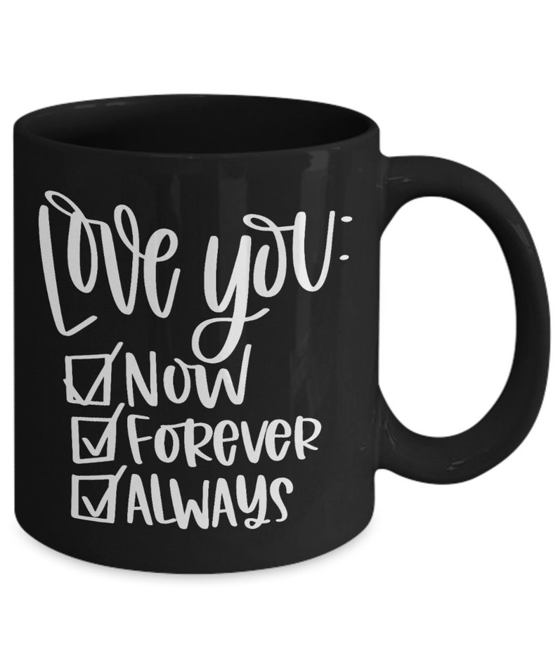 May include: Black ceramic coffee mug with white text that reads "Love you: Now, Forever, Always" with checkmarks next to each word.