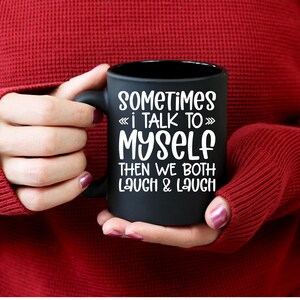 May include: Black coffee mug with white text that reads "Sometimes I talk to myself then we both laugh & laugh".