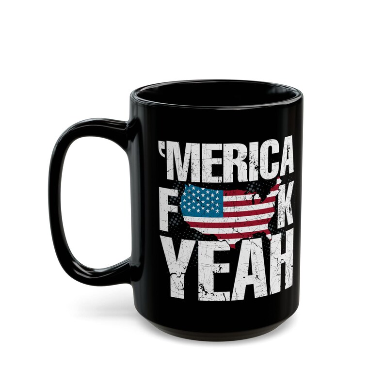 May include: A black ceramic mug featuring the white distressed text 'MERICA F*CK YEAH with a graphic of the United States map filled with the American flag pattern. The design is centered on the front of the mug, which has a curved handle.