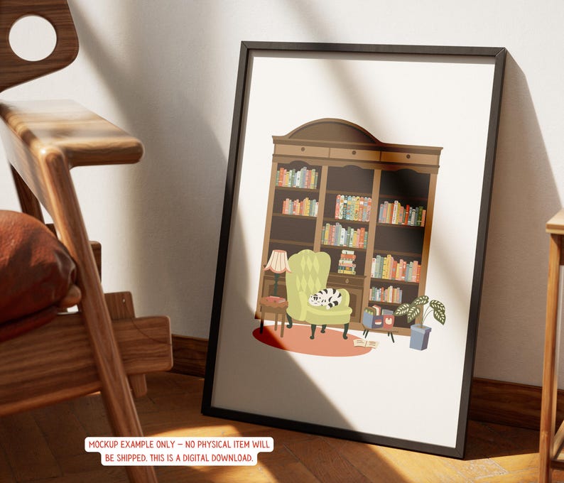 May include: A framed art print depicts a cozy reading nook. The illustration features a large bookshelf filled with colorful books, a green armchair with a cat, a small table, and a lamp. The artwork is in a black frame.