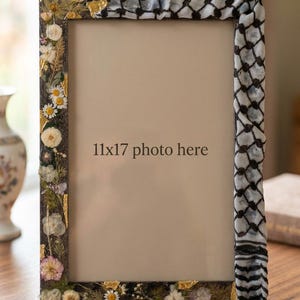 Könnte beinhalten: Rechteckiger Fotorahmen mit floralem und Blattgold-Design auf der linken Seite und einem schwarz-weißen Muster auf der rechten Seite. Der Rahmen ist mit "11x17 photo here" beschriftet.