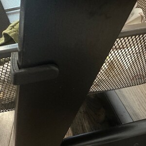 Puede incluir: Primer plano de una estanter&iacute;a de metal negro con una cesta de alambre. La cesta est&aacute; parcialmente llena de art&iacute;culos y la estanter&iacute;a tiene un marco de metal negro.