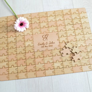 May include: A wooden jigsaw puzzle with a light brown finish. The puzzle is personalised with the names "Emily & John" and the date "14th May 2015".