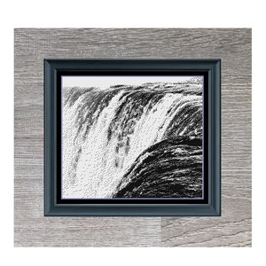 Könnte beinhalten: Ein Schwarzweißbild eines Wasserfalls in einem grauen Holzrahmen. Das Bild trägt den Titel "Waterfall".