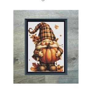 May include: Cross stitch pattern of a gnome holding a pumpkin. The gnome is wearing a plaid hat and has a brown beard. The pattern is 89 stitches wide by 125 stitches high and uses 27 DMC colors. "Mini Pumpkin Gnome"