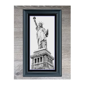 Peut inclure: Photographie en noir et blanc de la Statue de la Liberté dans un cadre noir. Le cadre est sur un fond en bois. Le texte "Statue Of Liberty" est sous l'image.