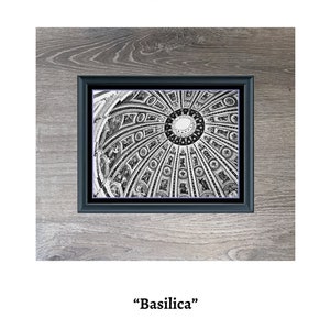 Puede incluir: Imagen en blanco y negro de un techo abovedado con intrincados detalles. La imagen está enmarcada en un marco negro y colocada sobre un fondo de veta de madera. El texto "Basilica" y "380 x 280" está impreso debajo de la imagen.
