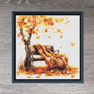 Peut inclure: Modèle de point de croix d'un banc avec une couverture dessus, entouré de feuilles d'automne. Le motif est intitulé "Autumn Bench" et mesure 200 points de large sur 198 points de haut.