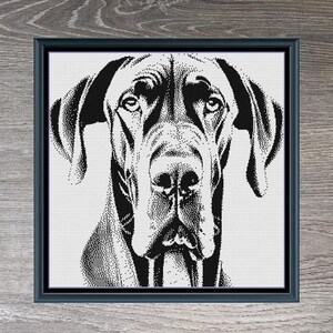 May include: Black and white cross-stitch pattern of a Great Dane dog's head. The pattern is framed in a wood-grain frame. The text "Great Dane Monochrome" and "260 x 260" is below the frame.
