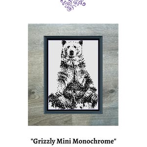 Könnte beinhalten: Schwarzweißes Kreuzstichmuster eines sitzenden Grizzlybären. Das Muster ist in einem Holzrahmen gerahmt. Der Titel "Grizzly Mini Monochrome" befindet sich unter dem Bild. Die Größe beträgt 90 x 125 Stiche und verwendet 1 DMC-Farbe.