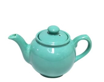 May include: A teal ceramic teapot with a lid and a spout. The teapot is round and has a smooth, glossy finish.
