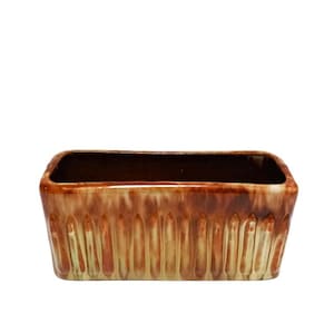 May include: A rectangular ceramic planter with a brown and green glaze. The planter has a textured design with vertical lines.