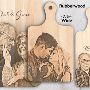 May include: Three personalised wooden chopping boards with engraved images of couples and their names. The boards are made of rubberwood and come in two sizes: 19 cm wide and 14 cm wide.