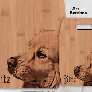 May include: Two wooden chopping boards with a laser engraved image of a dog. The larger board has the name "Blitz" engraved on it. The smaller board has a handle and the name "Blitz" engraved on it.