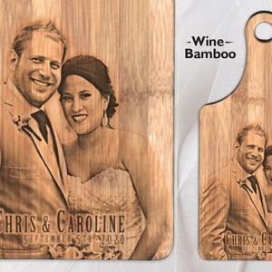 May include: A personalised bamboo chopping board with a laser-engraved photo of a couple. The board has a handle and the text "Chris & Caroline September 5th 2020" is engraved below the photo.