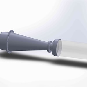 Puede incluir: Una boquilla cónica de metal gris conectada a un tubo de plástico transparente con una tapa gris en el extremo.