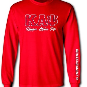 May include: Red long-sleeve t-shirt with white lettering that reads "ΚΑΨ Kappa Alpha Psi" and "ACHIEVEMENT" on the sleeve.