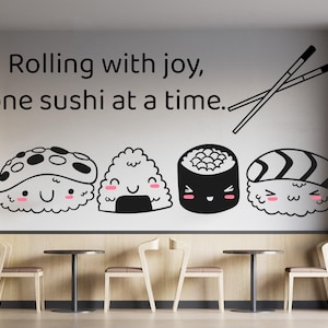 May include: A wall decal featuring the black text Rolling with joy, one sushi at a time, a pair of crossed chopsticks, and four cute, cartoon-style sushi characters with smiling faces and pink cheeks arranged in a horizontal row.