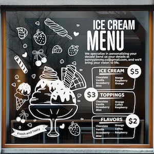 May include: A white vinyl window decal featuring an ice cream menu design. The graphic includes illustrations of ice cream cones, sundaes, strawberries, and cherries, alongside text listing ice cream, toppings, and flavors with prices.